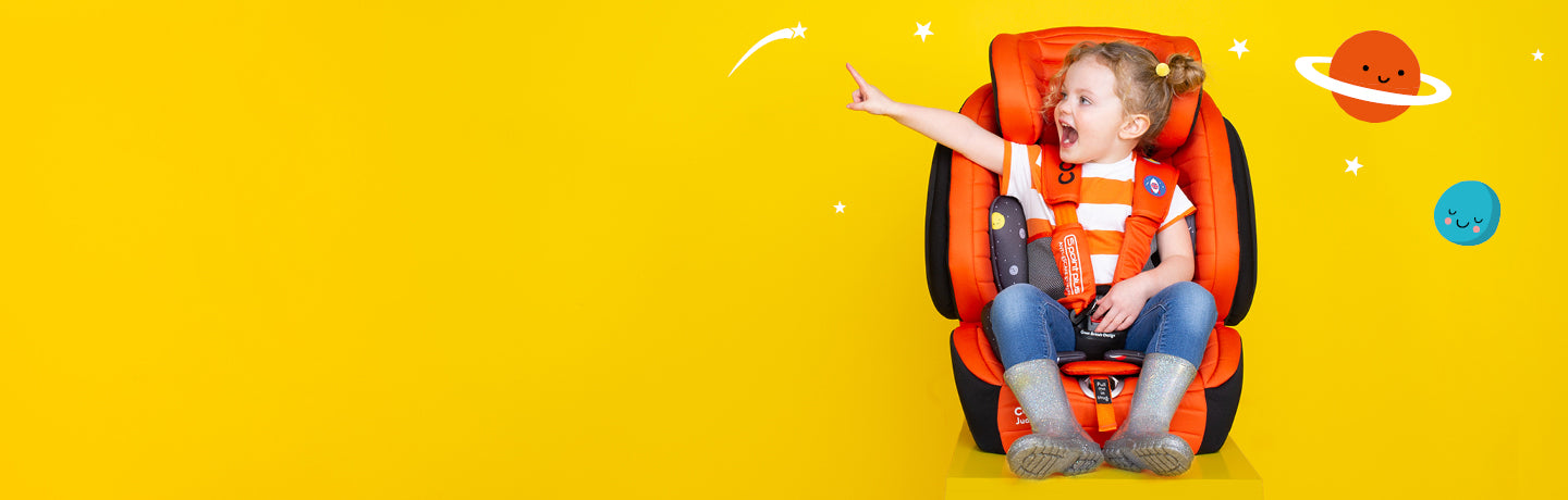 Young girl sitting in orange Cosatto car seat.